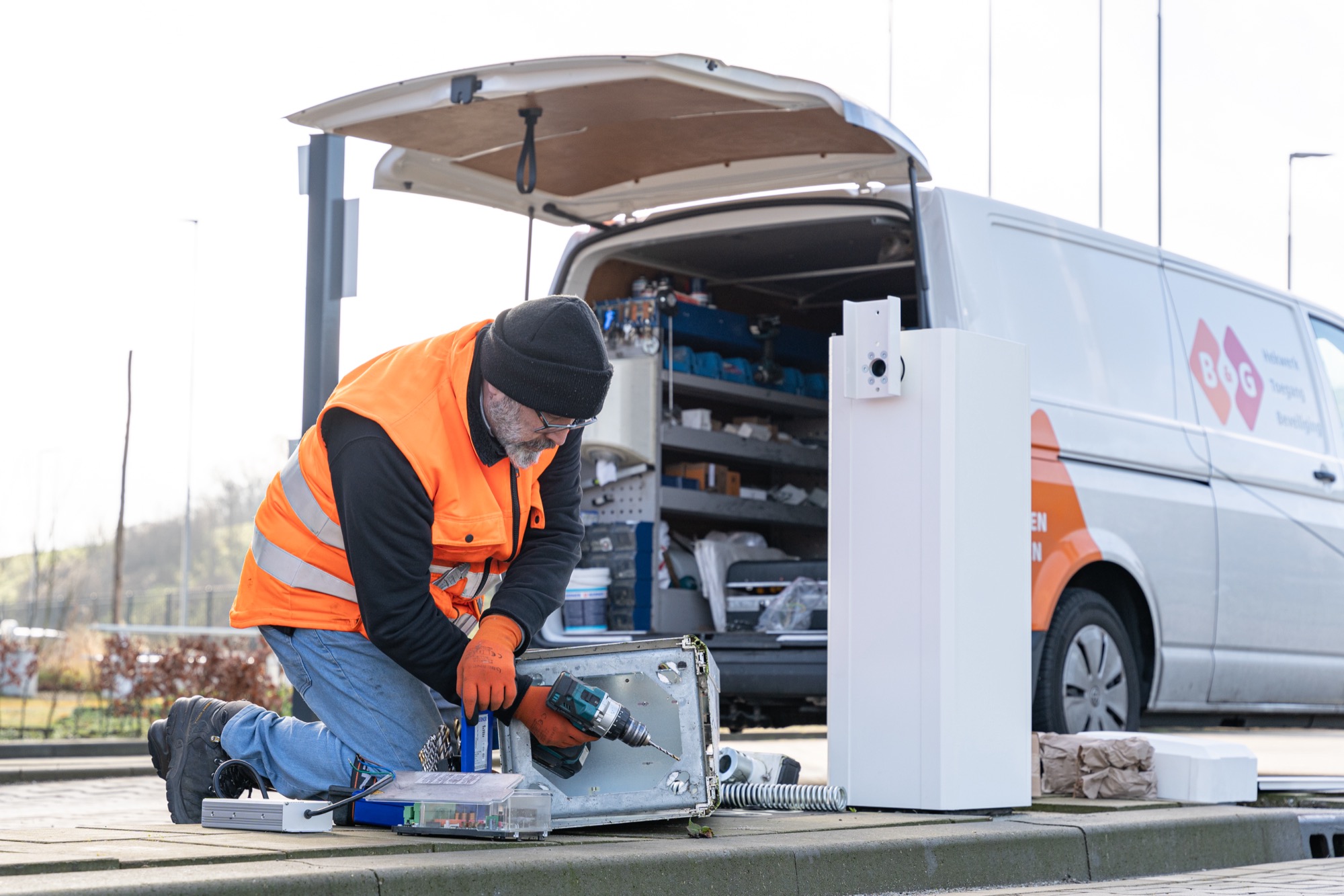 Servicemonteur werkt aan besturingskast van een toegangsinstallatie